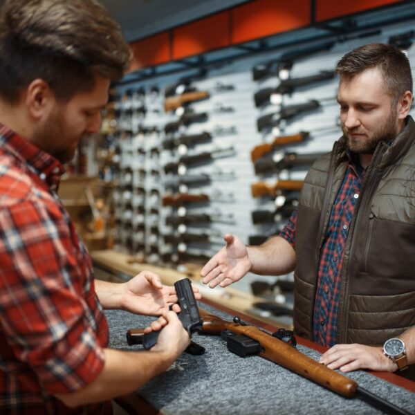 Arms dealer and client handling a gun